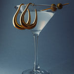 Large gold drop hoops styled in a martini glass