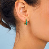 Model wearing green gemstone hoops