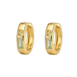 A pair of gold huggie hoop earrings, each featuring a small round clear stone and a larger rectangular light green baguette-cut stone, shown on a plain white background.