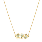 Gold necklace with three green gemstones on a white background