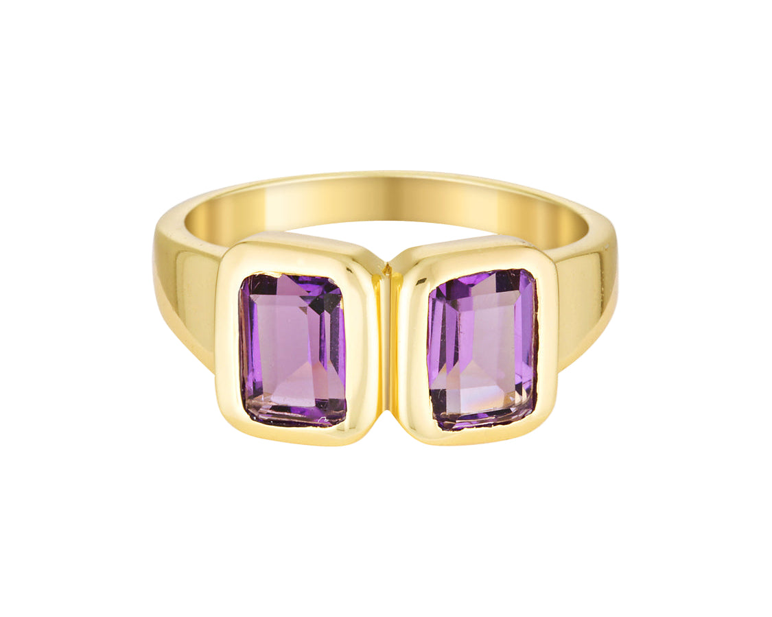Gold ring with purple gemstones on a white background