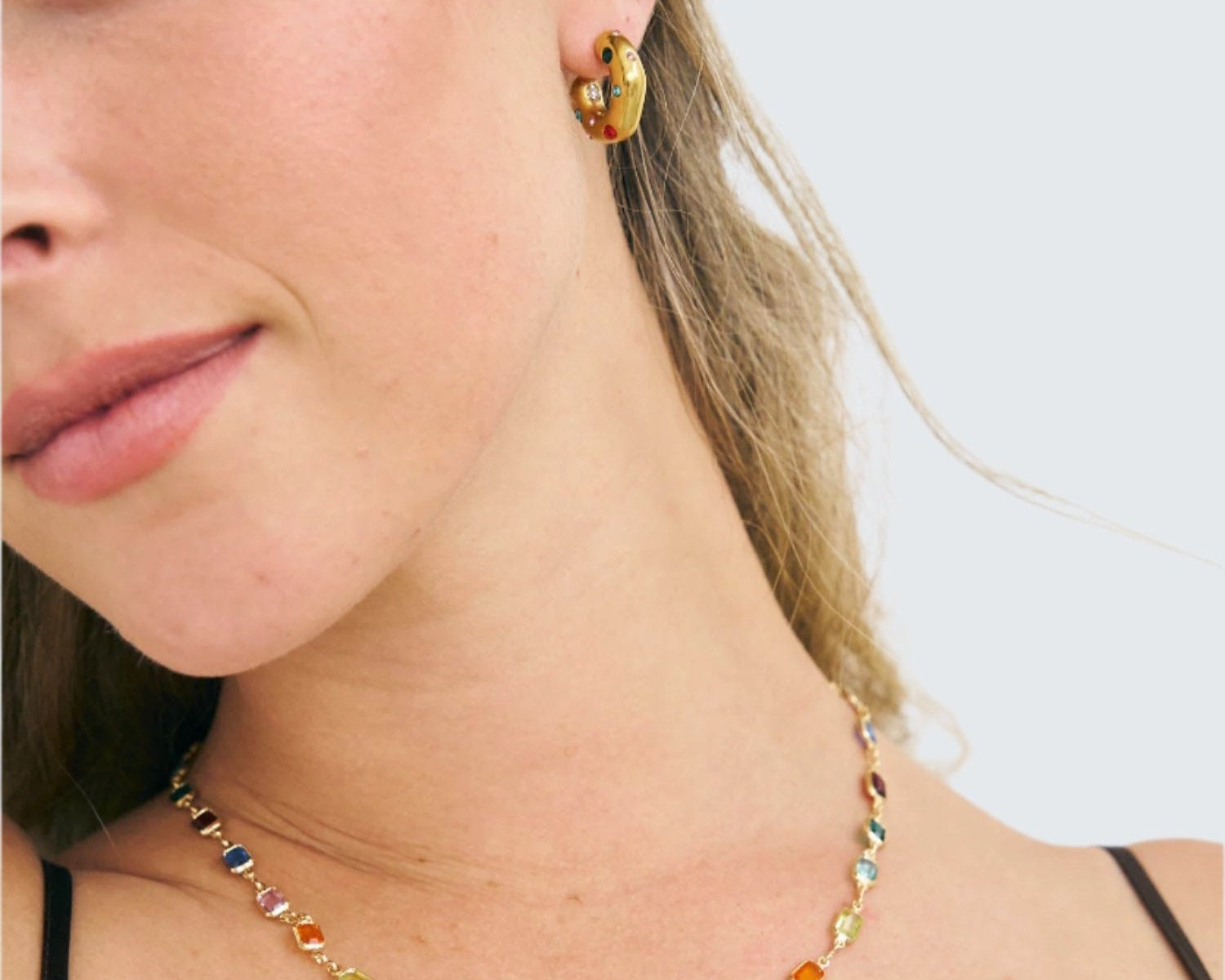 Model wearing rainbow necklace and coloured Carnival hoop earrings