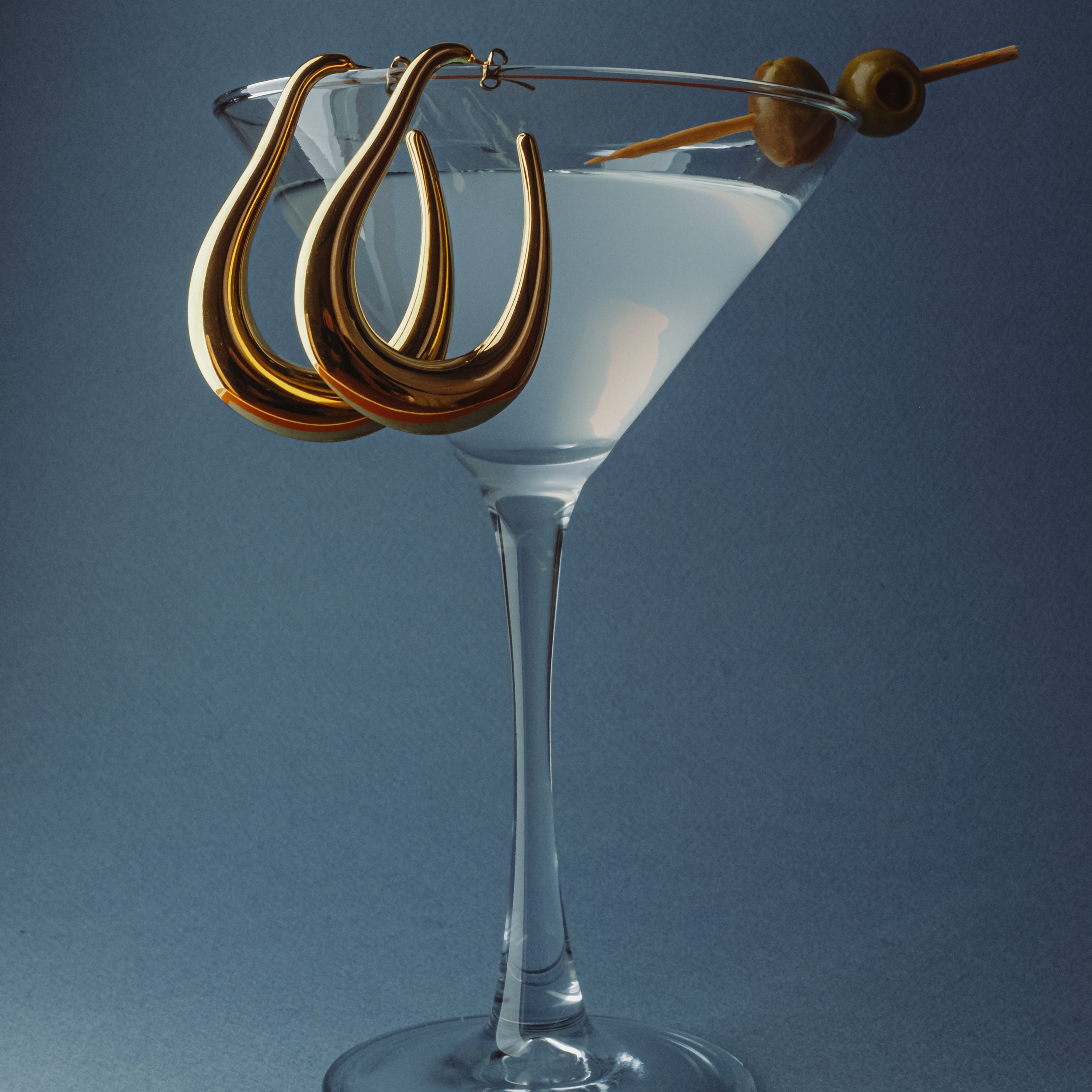 Large gold drop hoops styled in a martini glass 