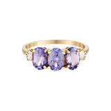 Gold ring with three oval purple amethyst gemstones on a white background