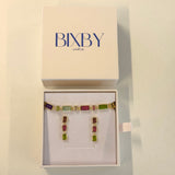 Multicolored gemstone earrings in a Bixby box on a beige background