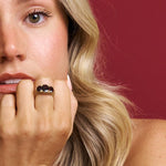 Woman with a ring on her finger against a red background