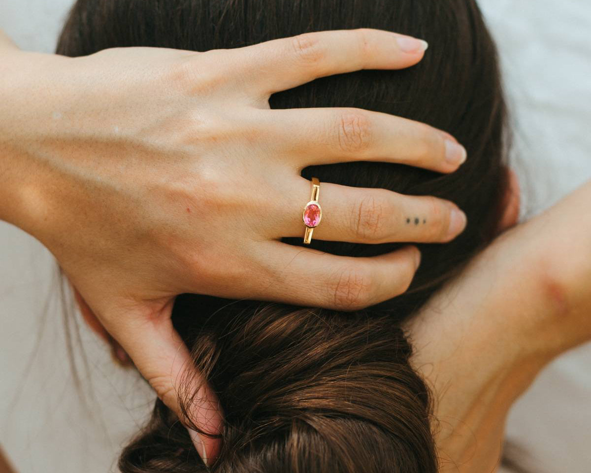 Person styling another person's hair with a close-up of a hand wearing a ring.