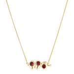 Gold necklace with three red gemstones on a white background