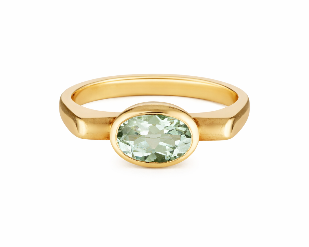 Gold ring with a green gemstone on a white background