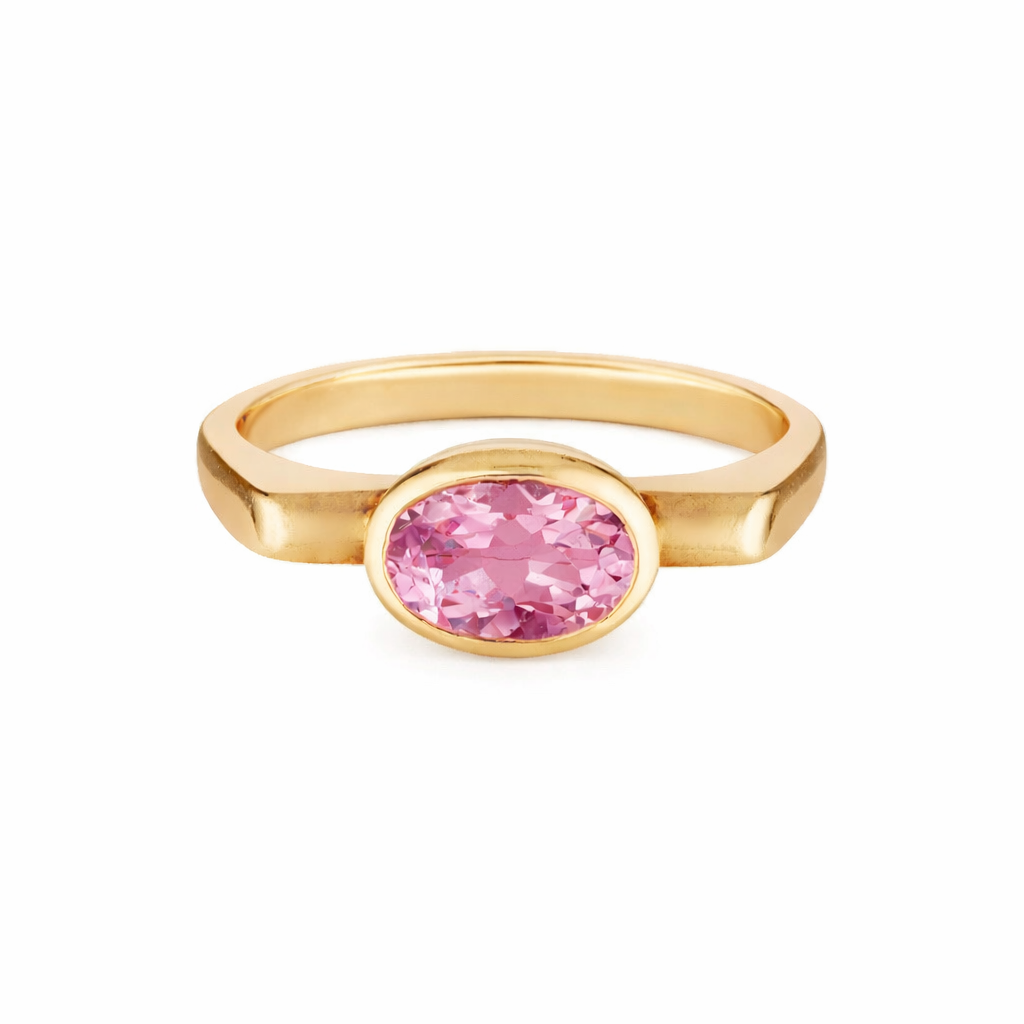 Gold ring with a pink gemstone on a white background