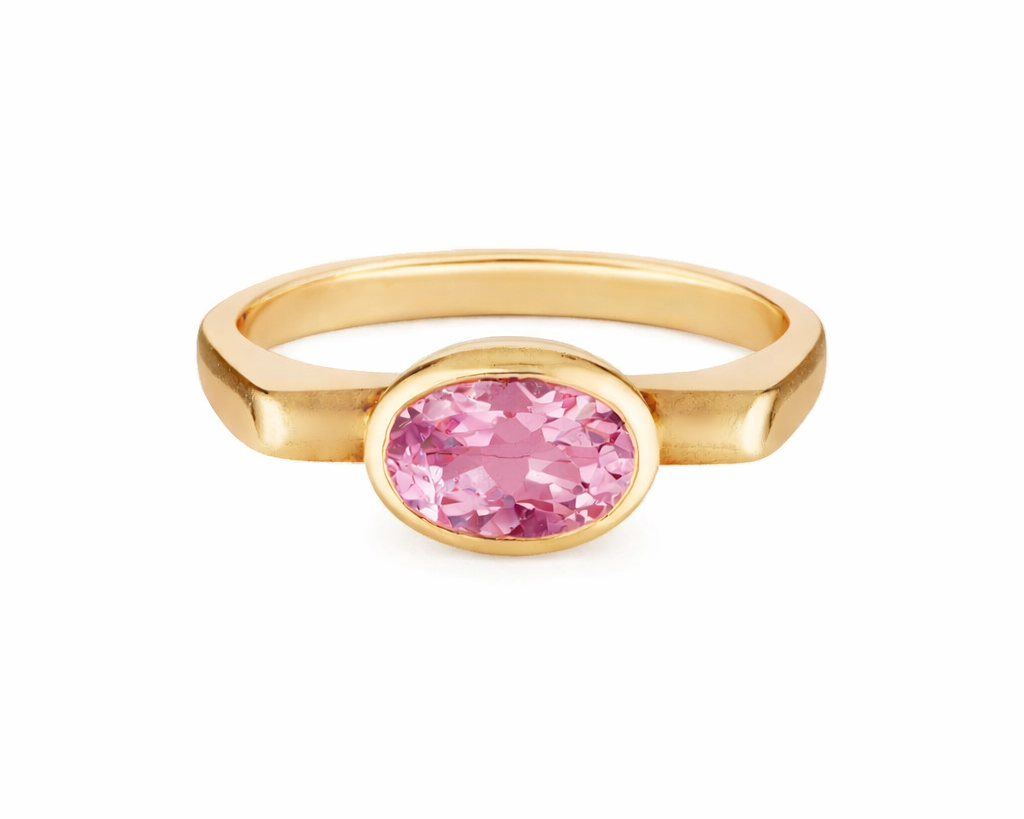 Gold ring with a pink gemstone on a white background