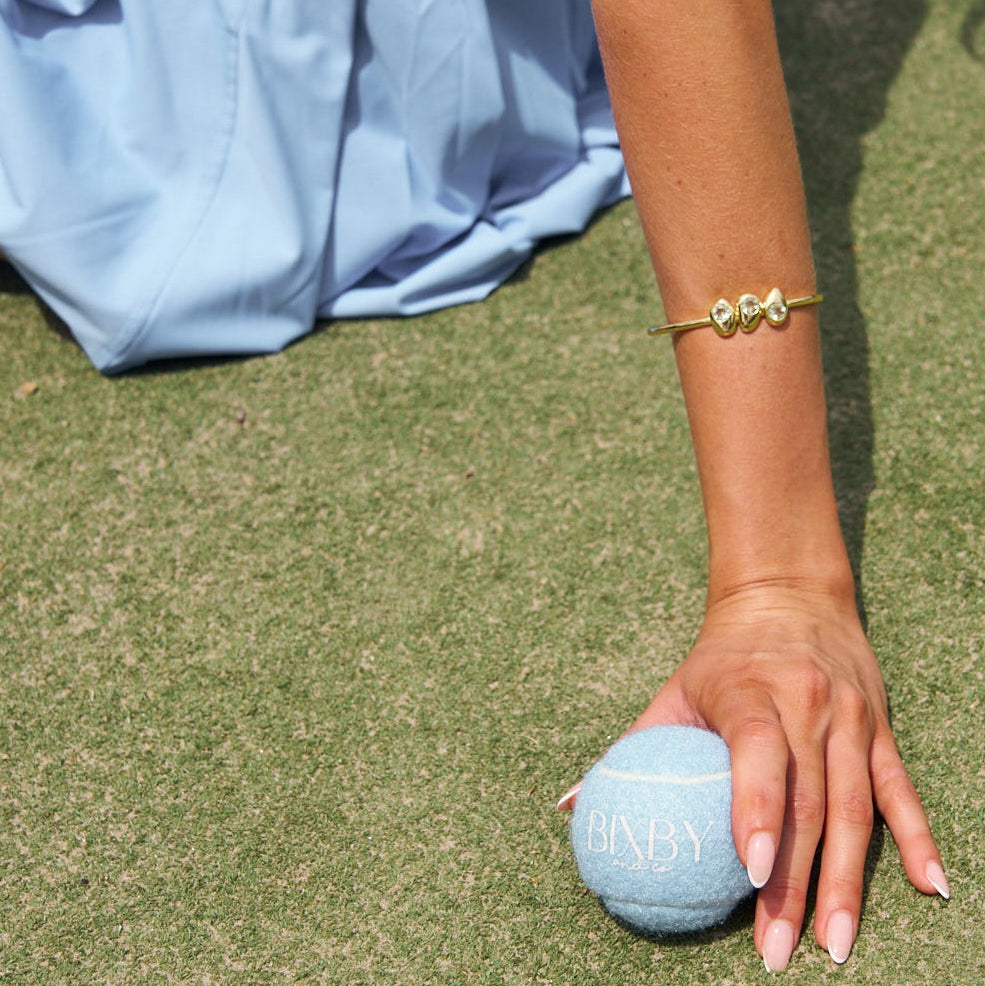 Person playing bocce ball on a grassy field