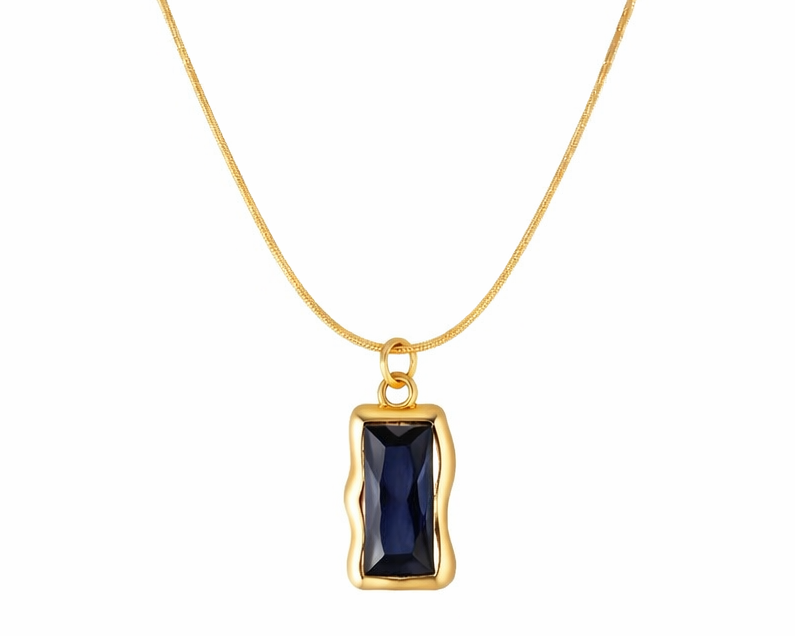 Gold necklace with a blue gemstone pendant on a white background