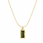 Gold necklace with a green pendant on a white background
