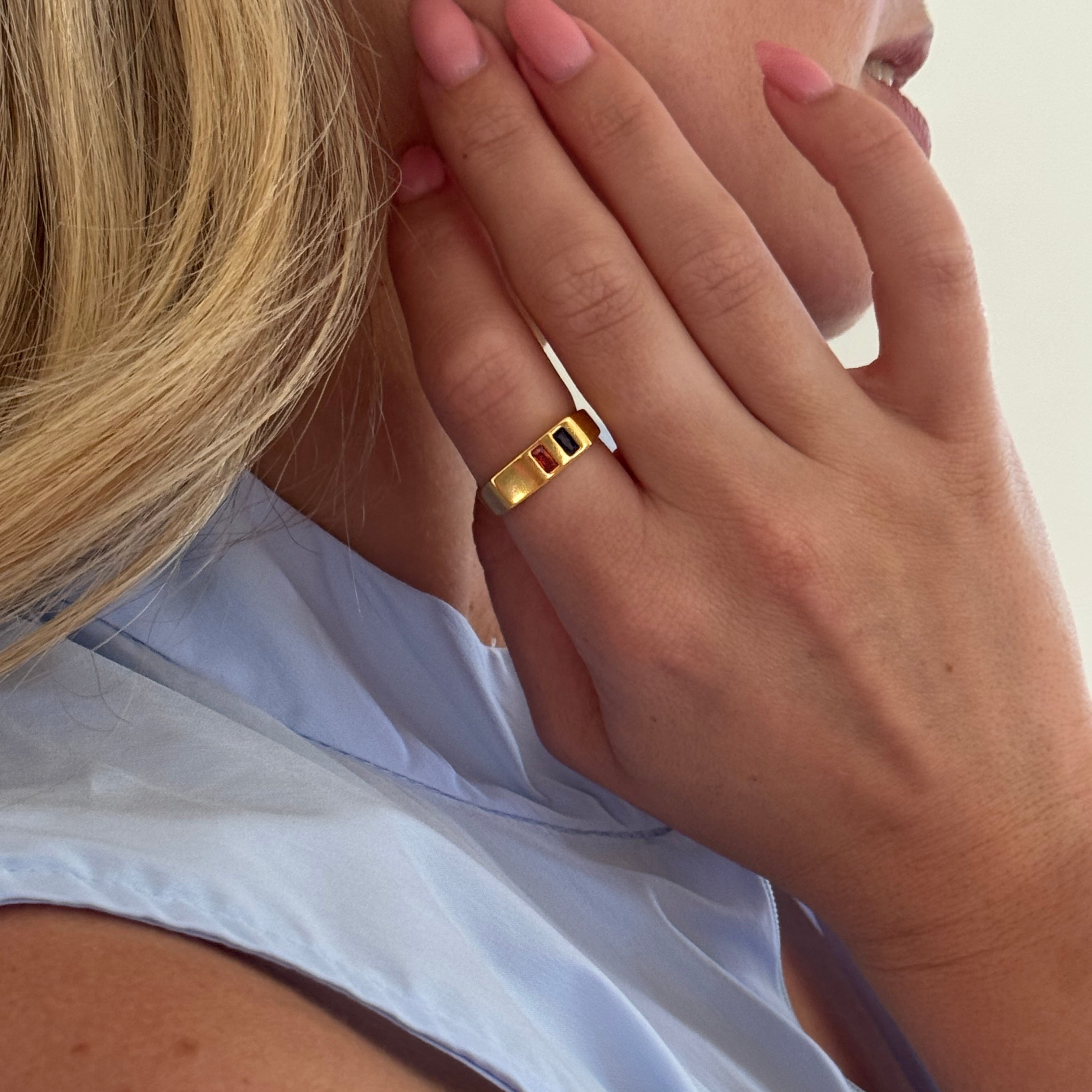 Close-up of a hand wearing a gold ring with a white background
