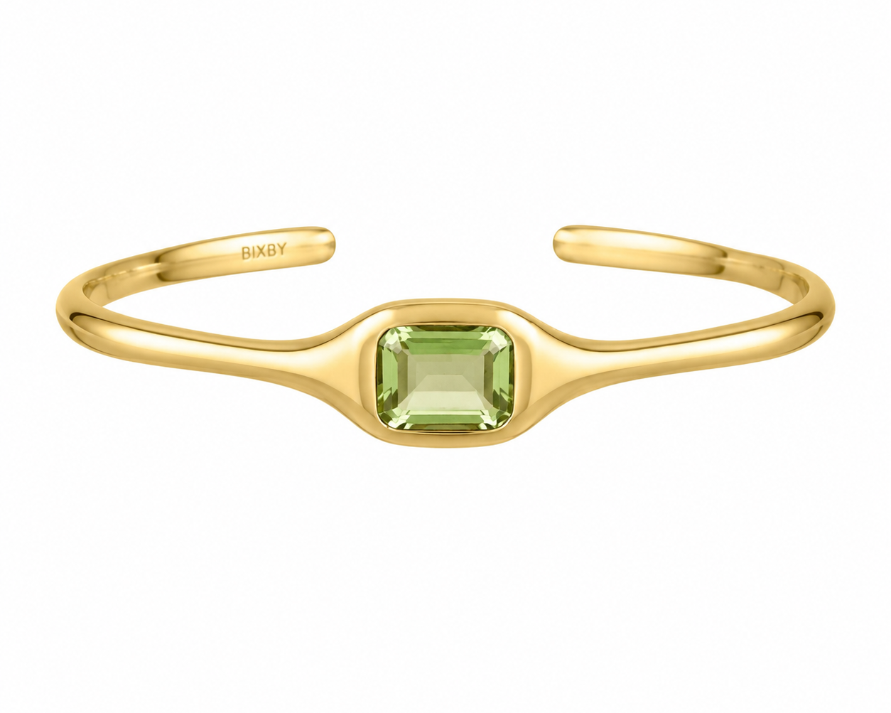 A gold open cuff bracelet featuring a central square-cut light green gemstone, with the brand name 'BIXBY' engraved on the inside, shown against a plain white background.