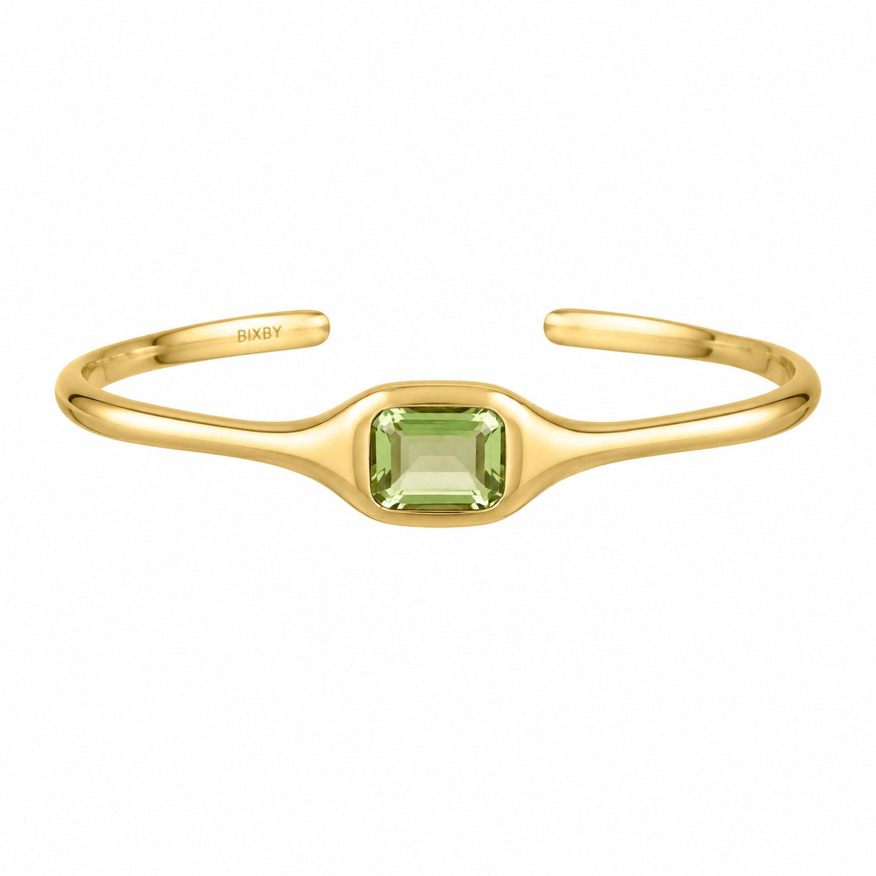 A gold open cuff bracelet featuring a central square-cut light green gemstone, with the brand name 'BIXBY' engraved on the inside, shown against a plain white background.