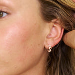 Close-up of a person wearing a Sterling Silver heart hoop earring.