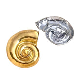 Gold and silver spiral-shaped objects on a textured beige surface