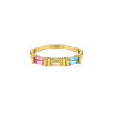 A gold ring featuring three rectangular baguette-cut gemstones in pink, yellow, and light blue, set against a plain light gray background.