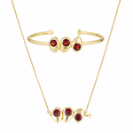 Gold bracelet and necklace set with red gemstones on a white background