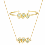 Gold bracelet and necklace set with green gemstones on a white background