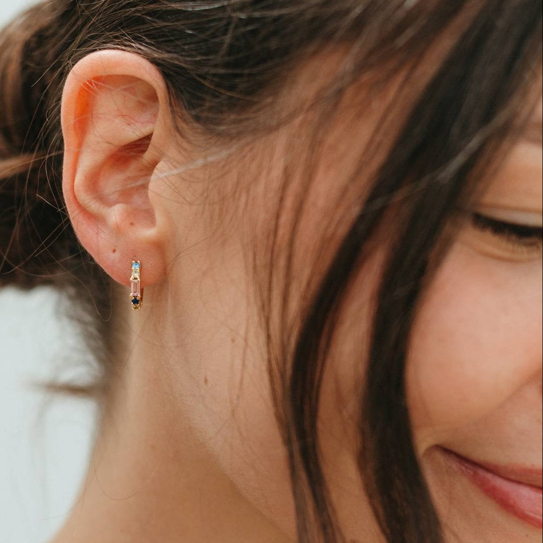 Close-up of a person wearing a small earring with a blurred background