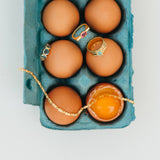 Eggs in a carton with jewelry items on top