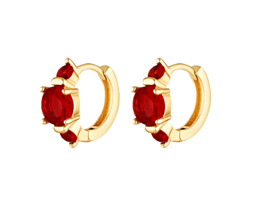 Gold hoop earrings with red gemstones on a white background