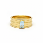 Gold ring with a rectangular blue gemstone on a white background