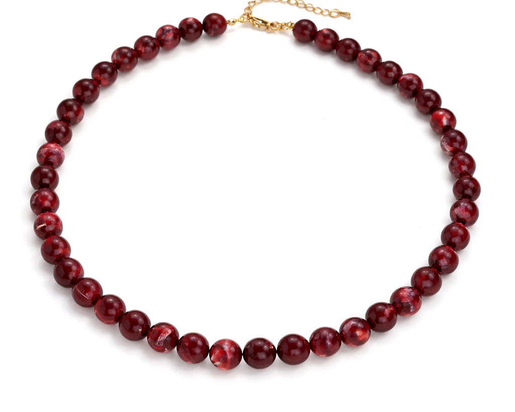 Red beaded necklace on a white background