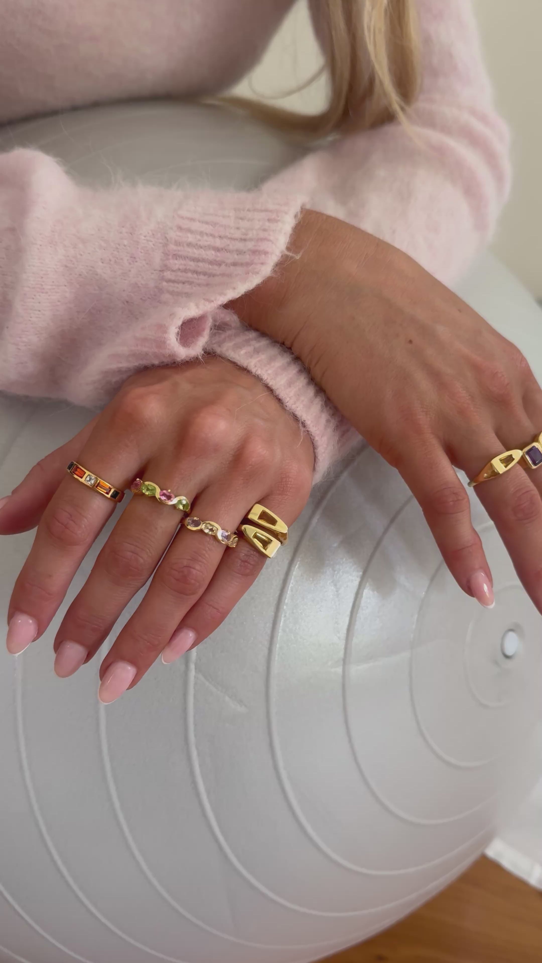 Model wearing multiple new gold rings 