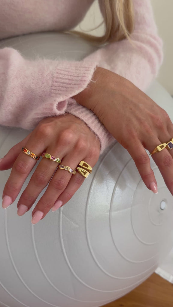 Model wearing multiple new gold rings 