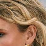 Model wearing shell shape 14k gold fill earrings 