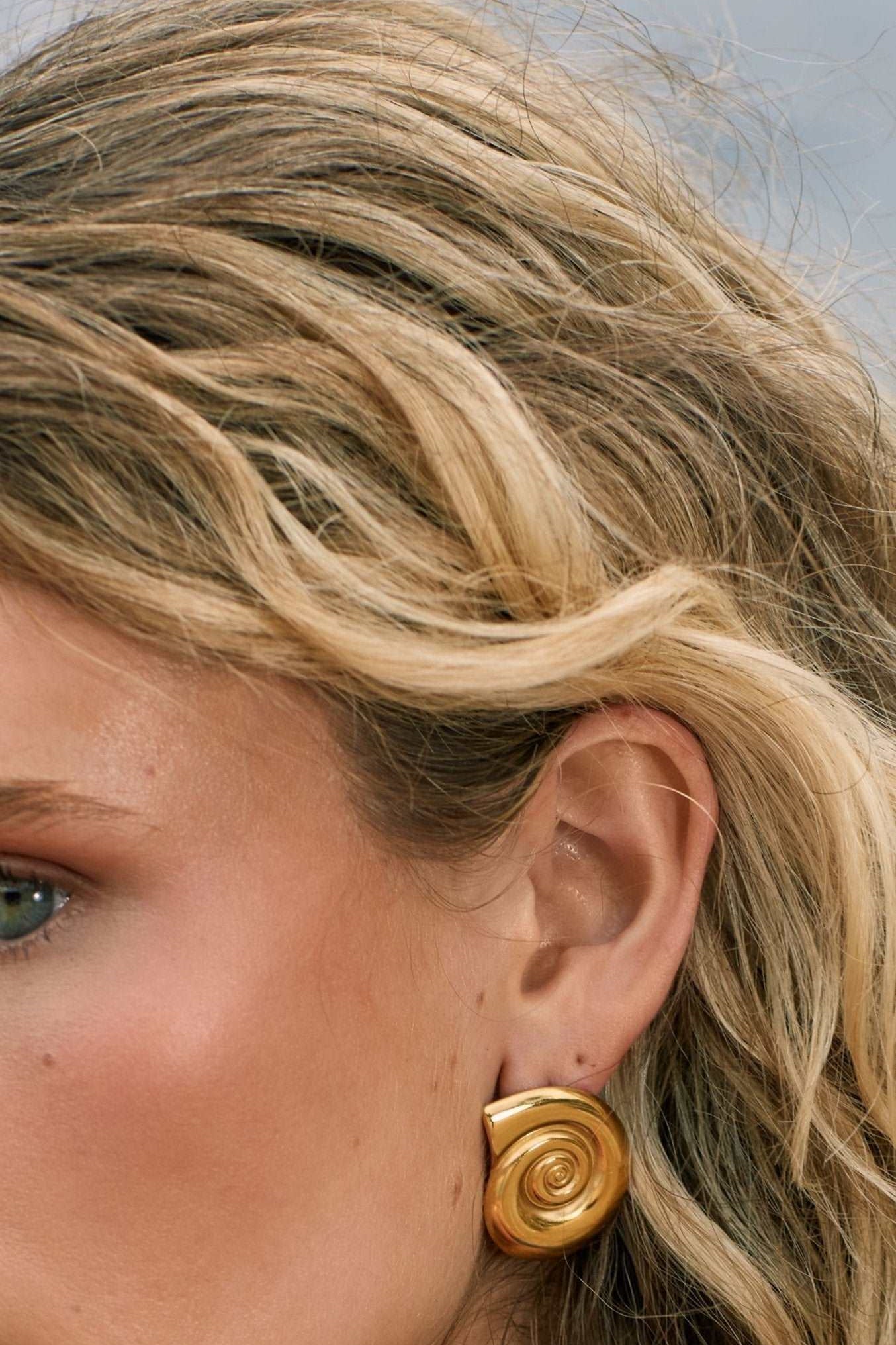 Model wearing shell shape 14k gold fill earrings 